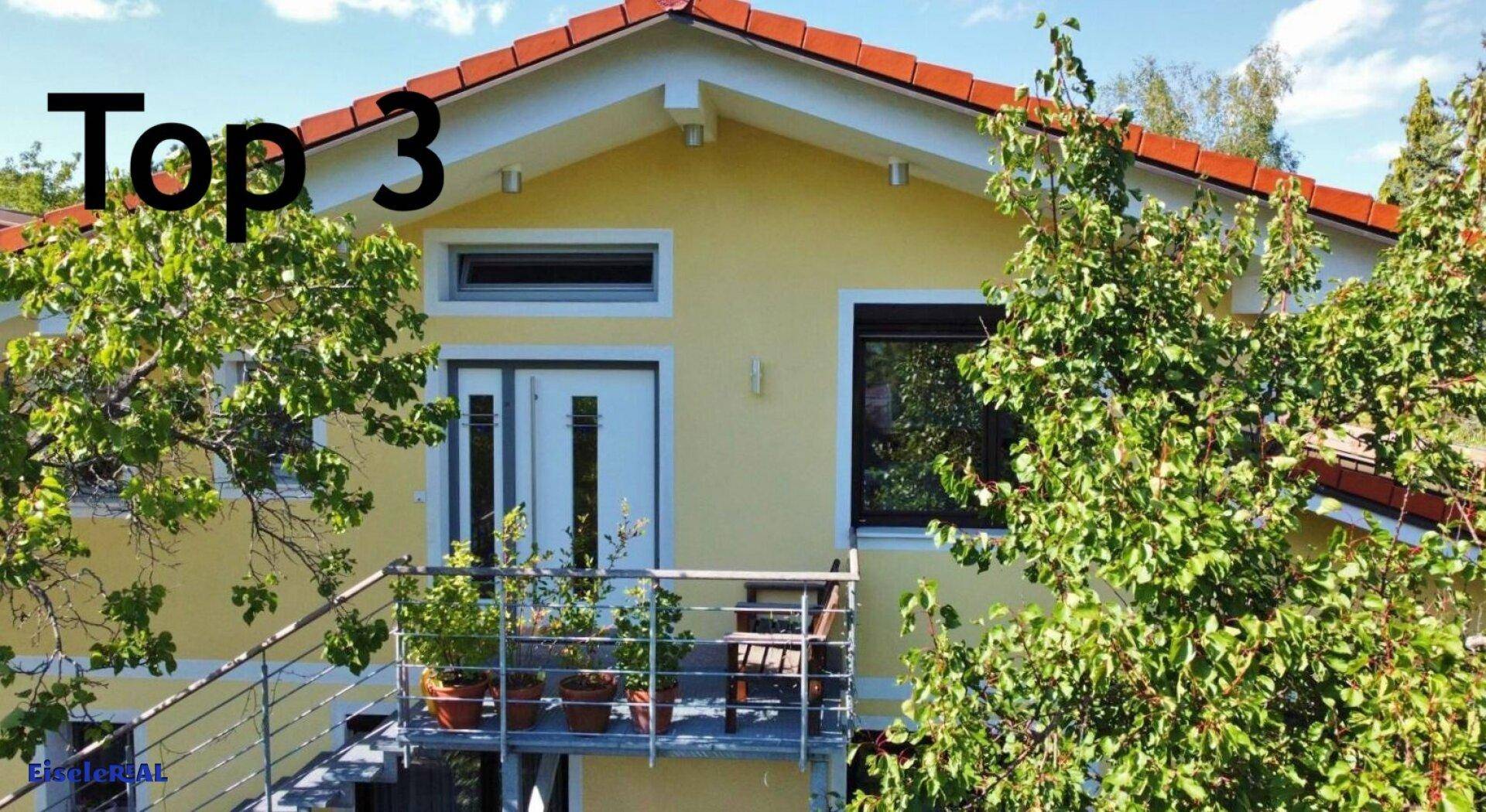Kleiner Balkon an der Hausfassade mit Pflanzen und Blick ins Grüne.