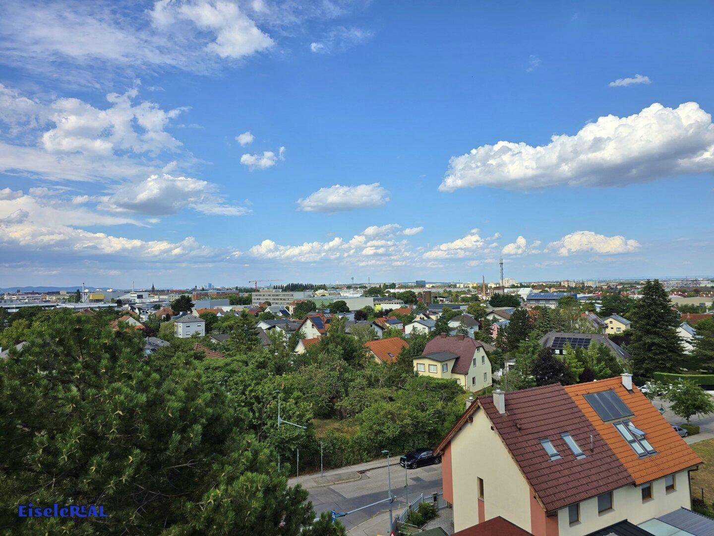 Weitläufiger Blick über eine Wohnsiedlung mit vielen Grünflächen und Häusern.