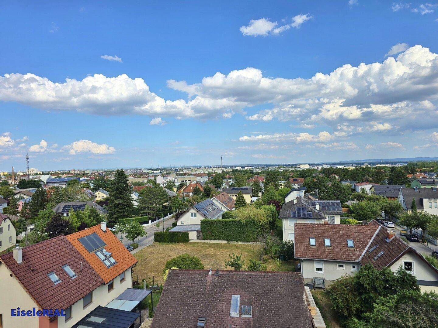 Panoramablick über eine Vorstadtsiedlung mit Einfamilienhäusern und viel Grün.