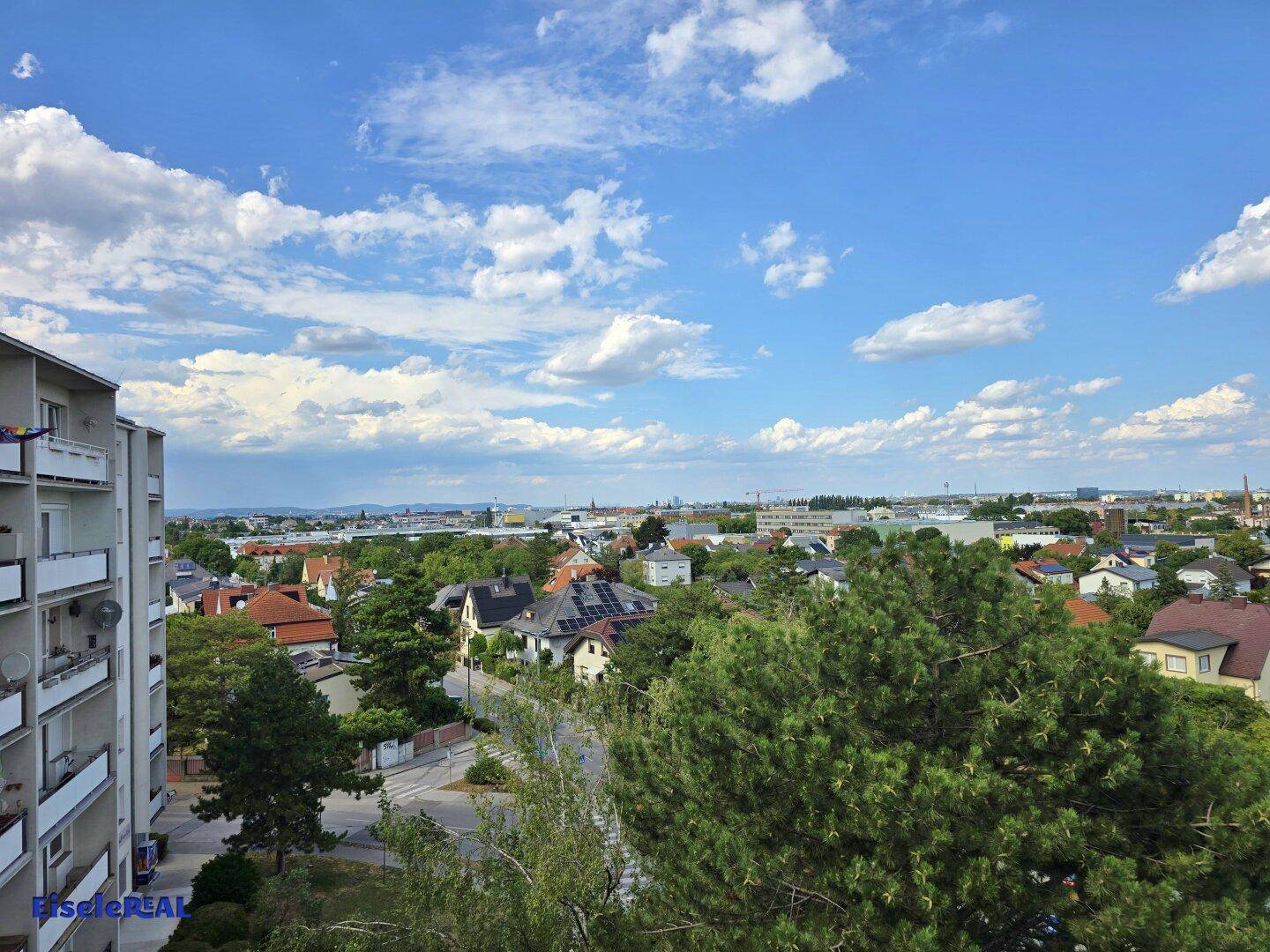 Weitblick über die Stadt und umliegende Natur von einem oberen Stockwerk.