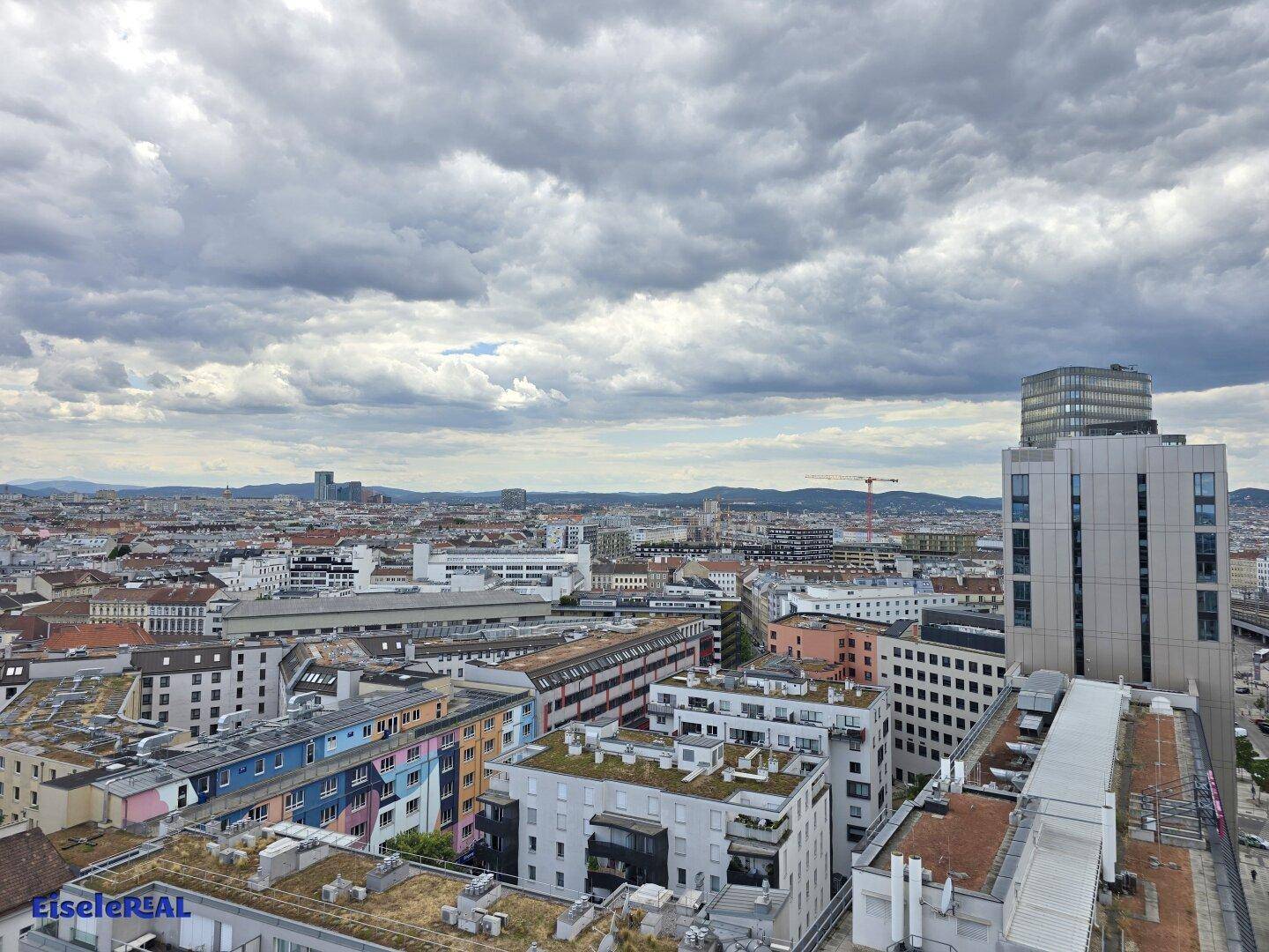 Ausgedehnter Stadtblick von oben, zeigt eine dichte Bebauung und den Horizont.
