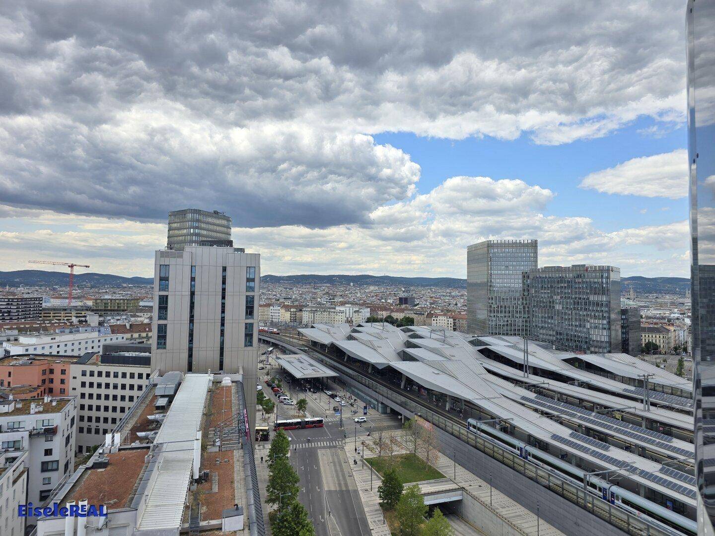 Panoramablick über die Stadt mit einem großen Bahnhof und umliegenden Hochhäusern.