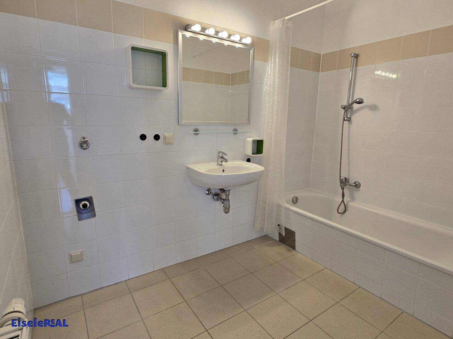 Funktionales Badezimmer mit Badewanne, Waschbecken und weißen Fliesen, bereit zur Nutzung.