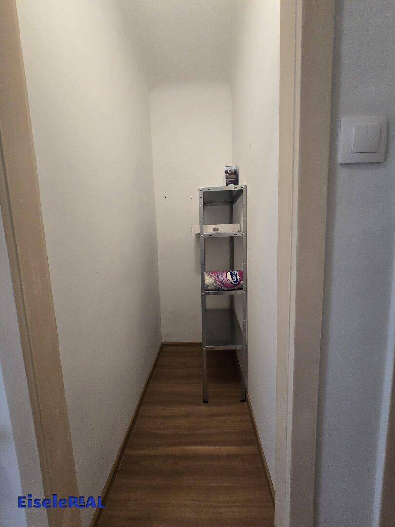 Kleiner Abstellraum mit Regalen und Laminatboden für zusätzlichen Stauraum.