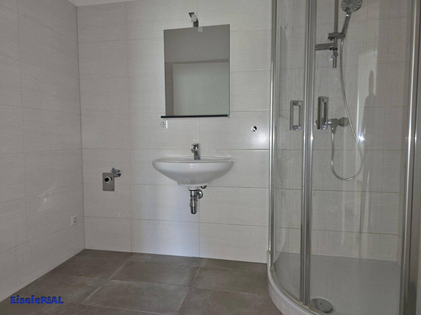 Modernes Badezimmer mit Duschkabine, Waschbecken und hellgrauen Wand- und Bodenfliesen.