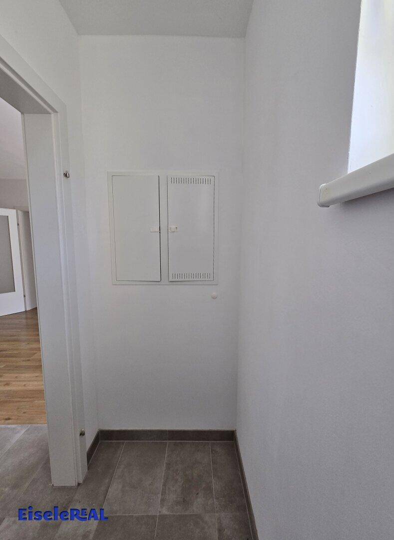 Eingangsbereich mit gefliestem Boden und weißen Wänden, bietet Zugang zu weiteren Räumen der Wohnung.