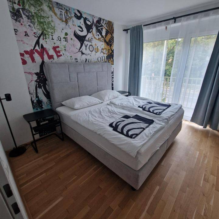 Schlafzimmer-mit-1x-Bett,-2x-Nachttisch,-Vorhaen