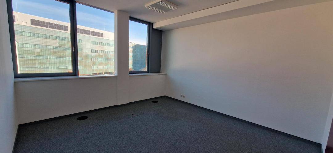Geräumiges Büro mit großen Fenstern, die viel natürliches Licht und einen Blick auf die Stadt bieten.