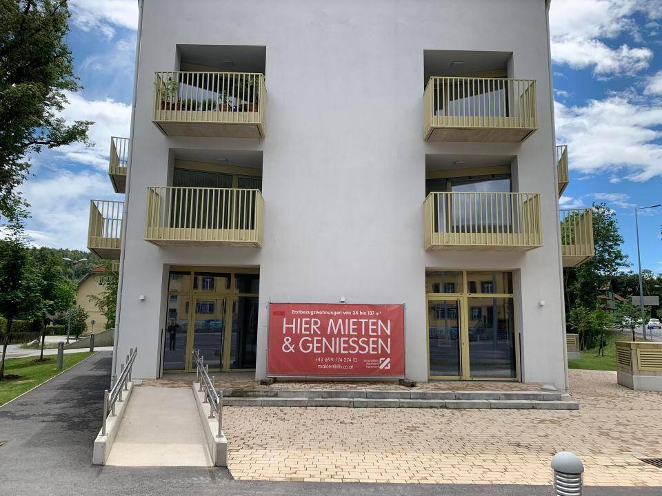 Vorderansicht des Neubaus mit barrierefreiem Zugang über eine Rampe und großen Fenstern.