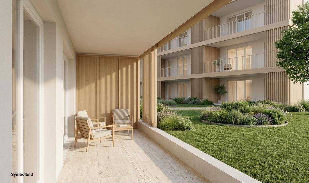 Großzügige Terrasse im Erdgeschoss mit Gartenblick und modernen Sitzgelegenheiten in einer Neubauanlage.