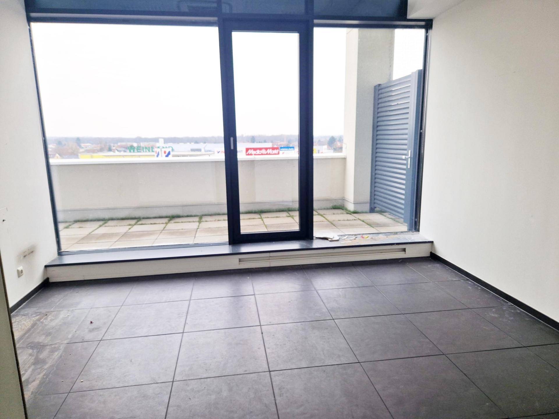 Kleinerer Büroraum mit Zugang zu einer Terrasse und weitem Blick über die Umgebung.