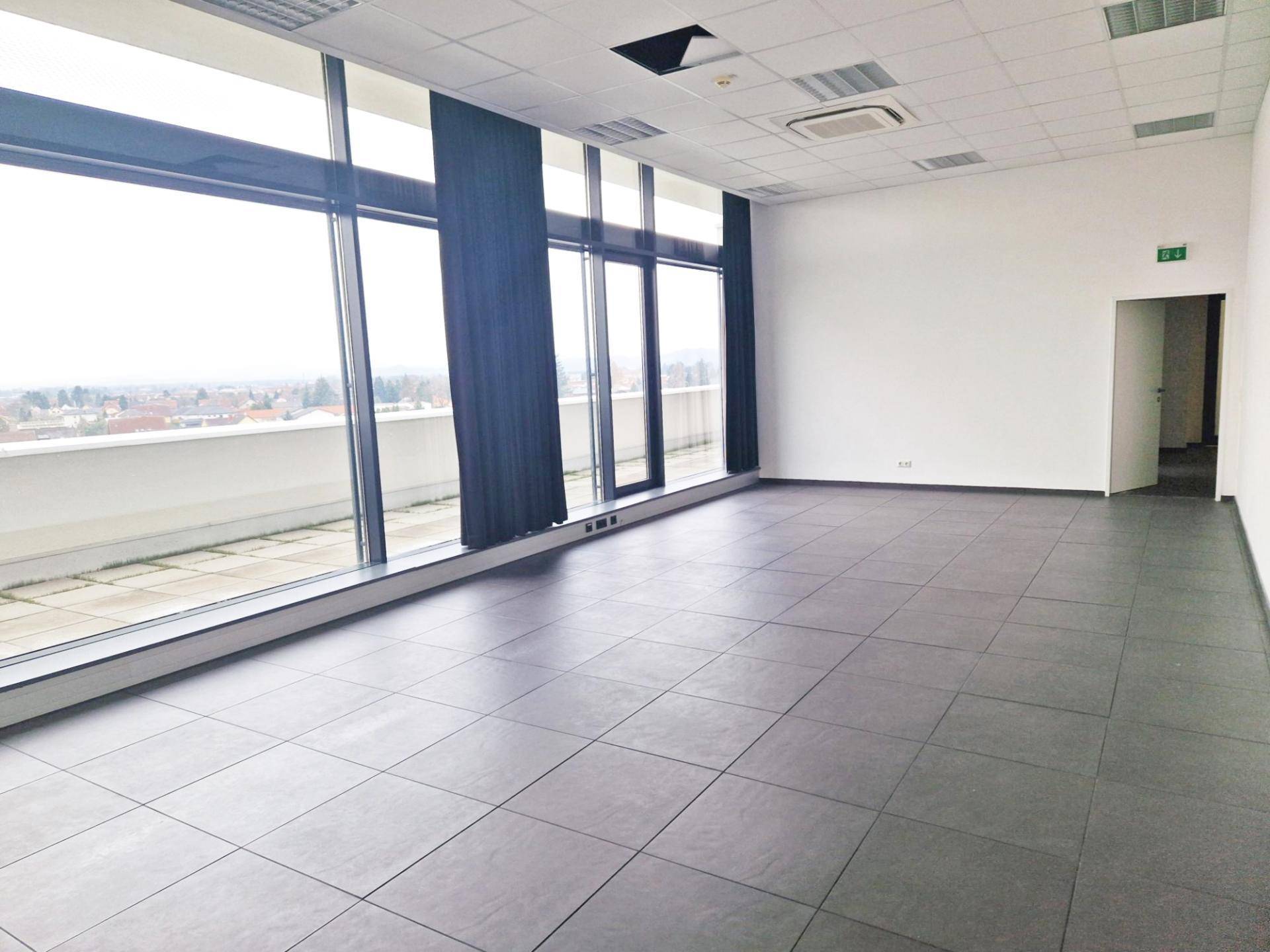 Helles Büro mit großen Fenstern, dunklen Vorhängen und Fliesenboden, bereit zur individuellen Gestaltung.