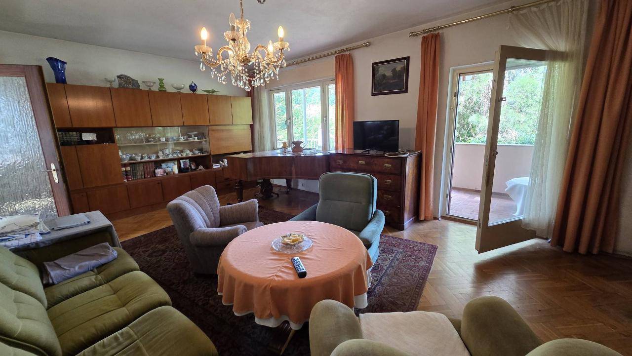 Helles Wohnzimmer mit großem Holzschrank, Teppich und direktem Zugang zum Außenbereich.