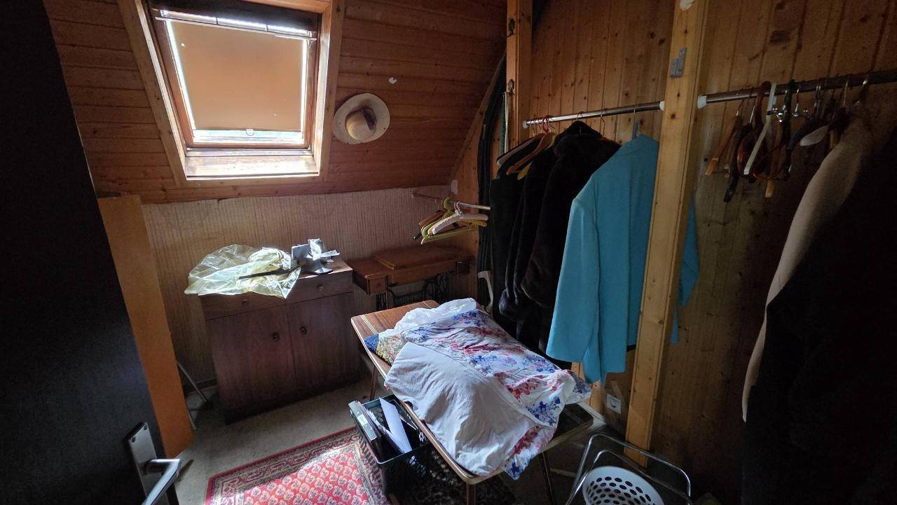Abstellraum im Dachgeschoss mit Dachfenster und Kleiderstange für zusätzlichen Stauraum.