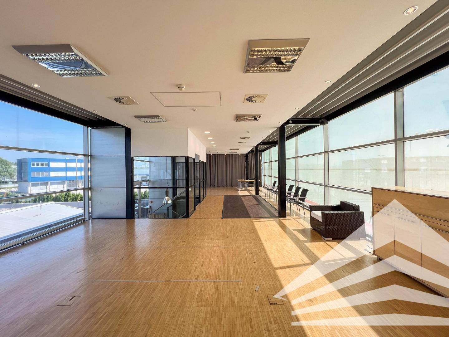 Großer, heller Open-Space-Bereich mit beeindruckender Glasfassade und weitem Ausblick.