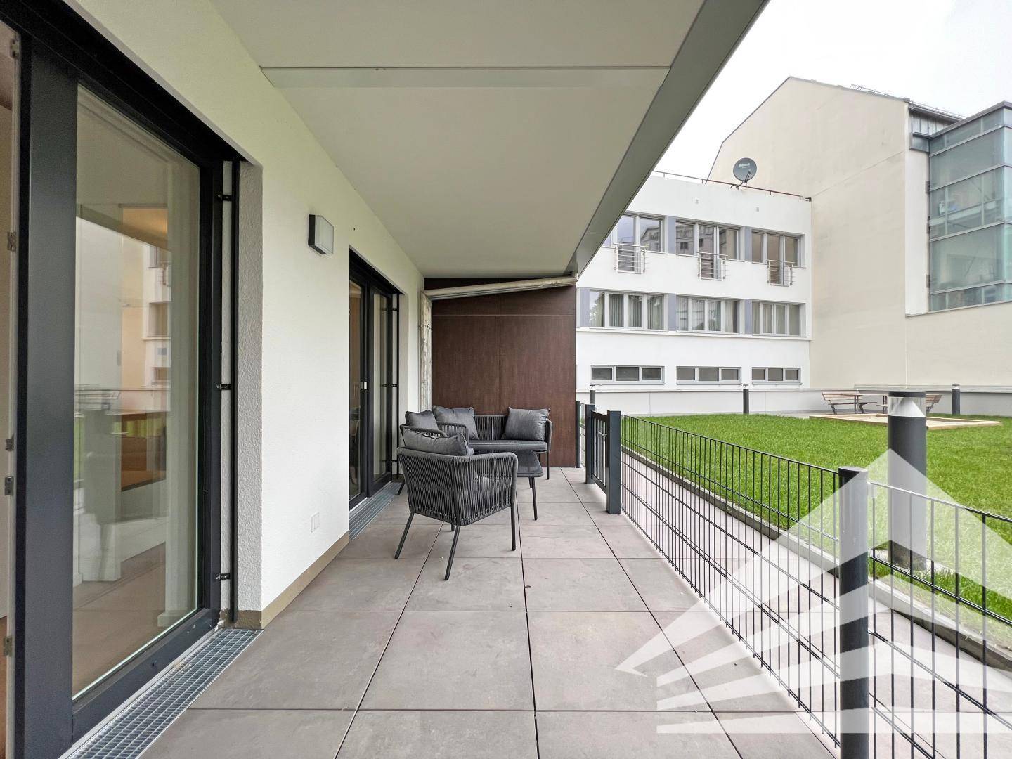 Geräumige Terrasse mit modernen Outdoor-Möbeln und Blick auf die umliegenden Gebäude.