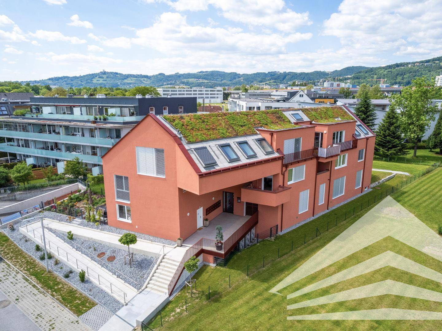 Ansicht der modernen Wohnanlage mit begrüntem Dach und Eingangsbereich.