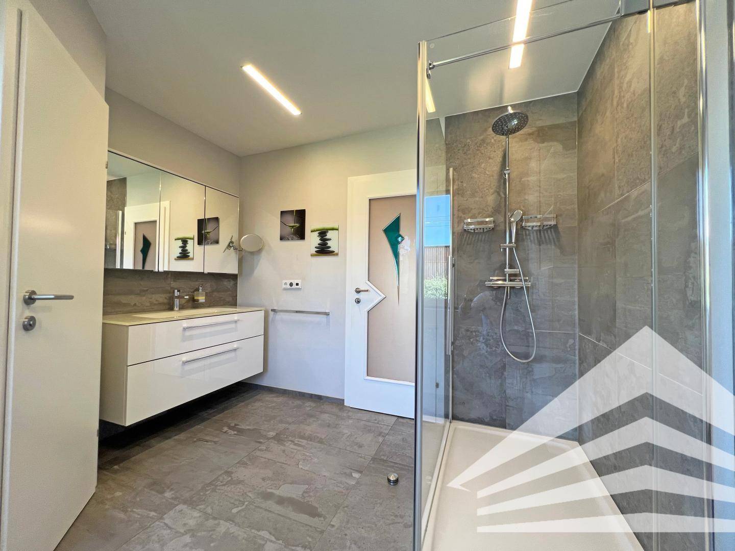 Elegantes Badezimmer mit Doppelwaschbecken, Spiegelschrank und begehbarer Dusche.
