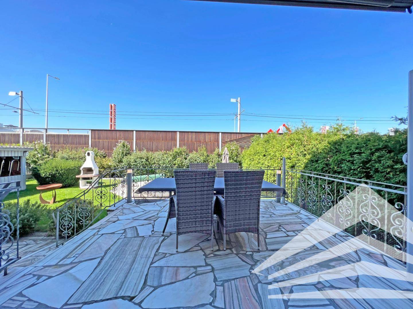 Gemütliche Terrasse mit Gartenmöbeln und Blick auf den Garten und die Umgebung.