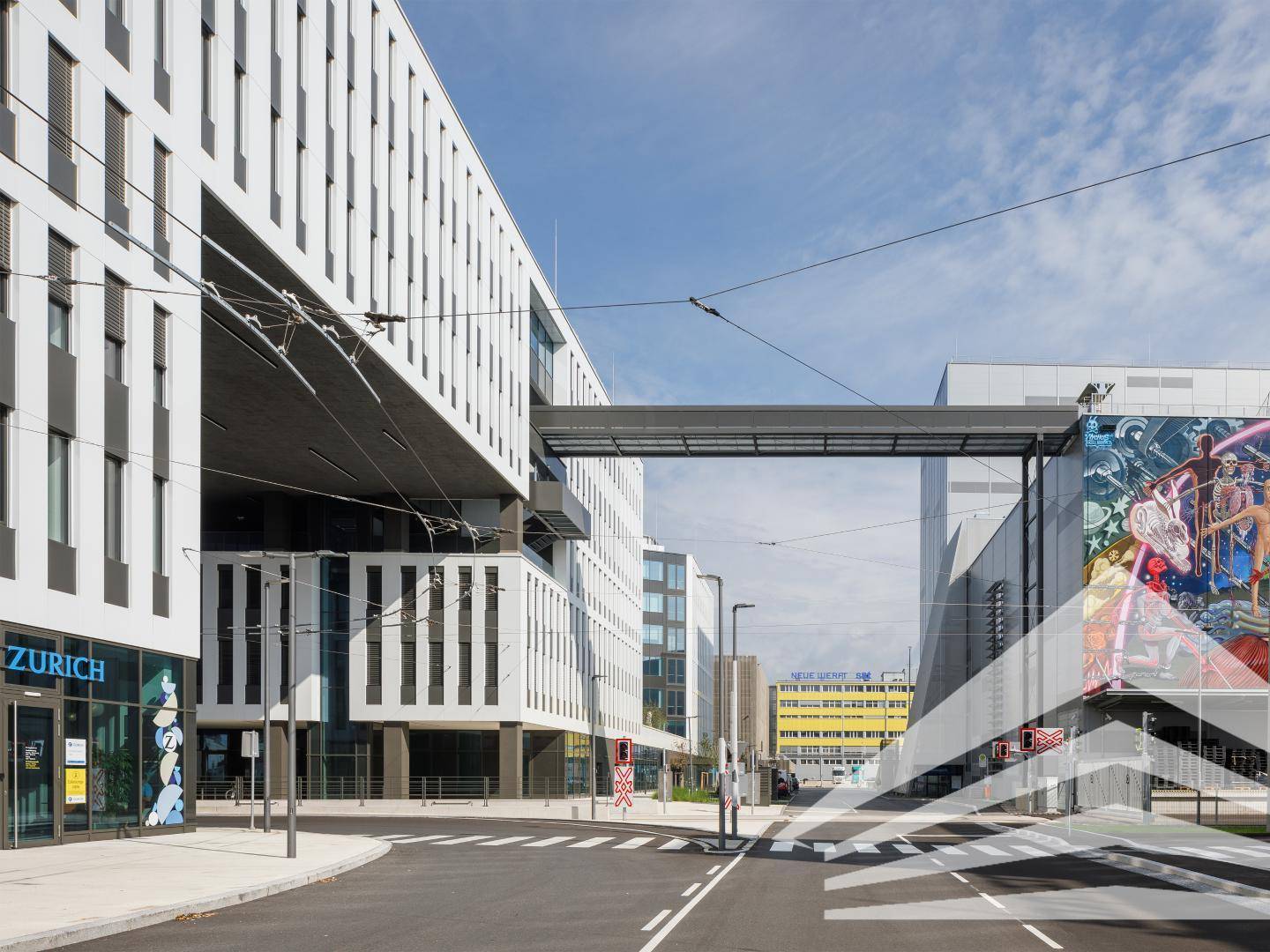 Moderne Bürogebäude mit einer Fußgängerbrücke und einer belebten Straße im Vordergrund, die das Stadtbild prägen.