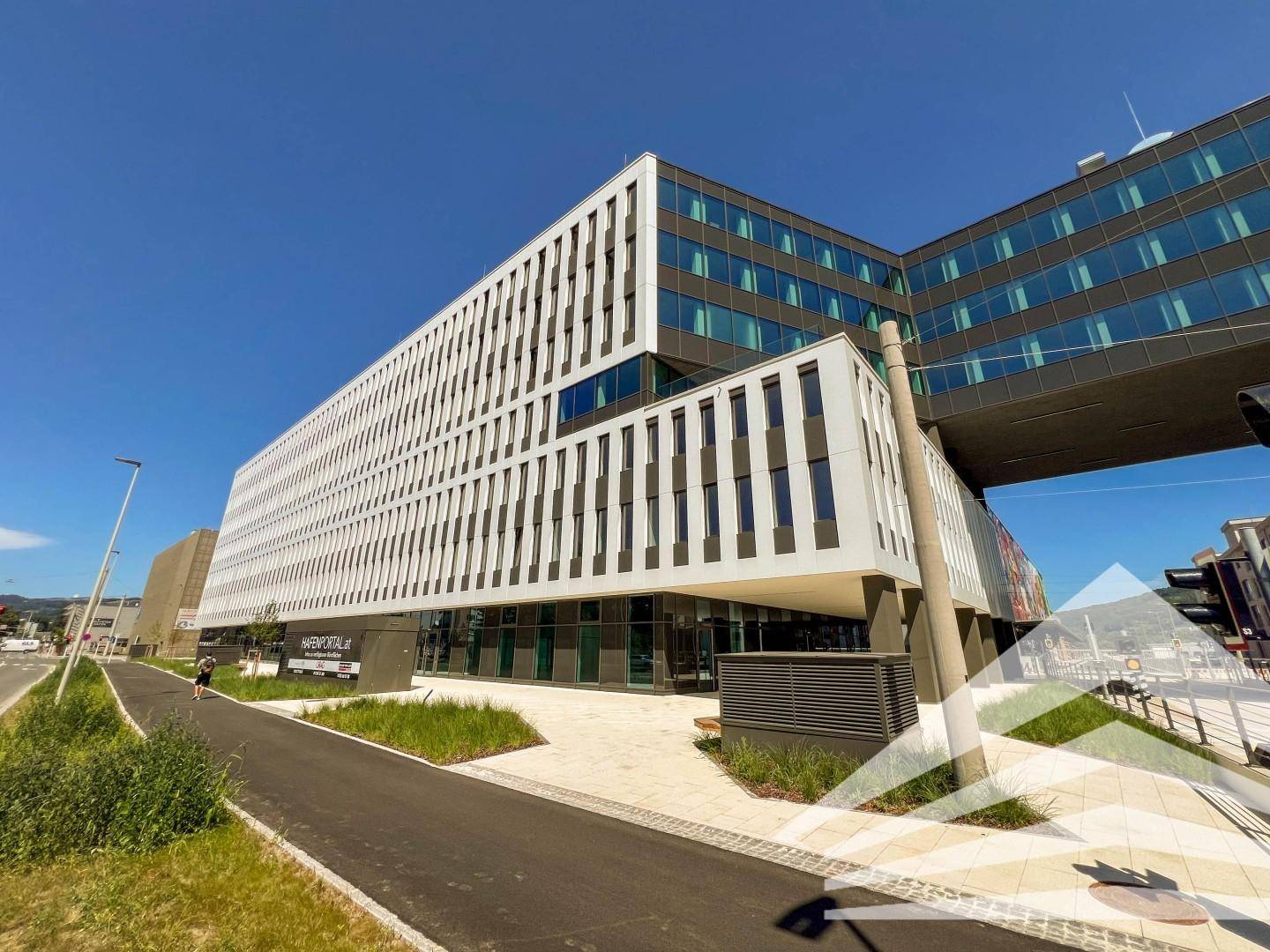 Ansicht eines großen, modernen Bürogebäudes mit vertikalen Lamellen und einer klaren, zeitgenössischen Architektur.