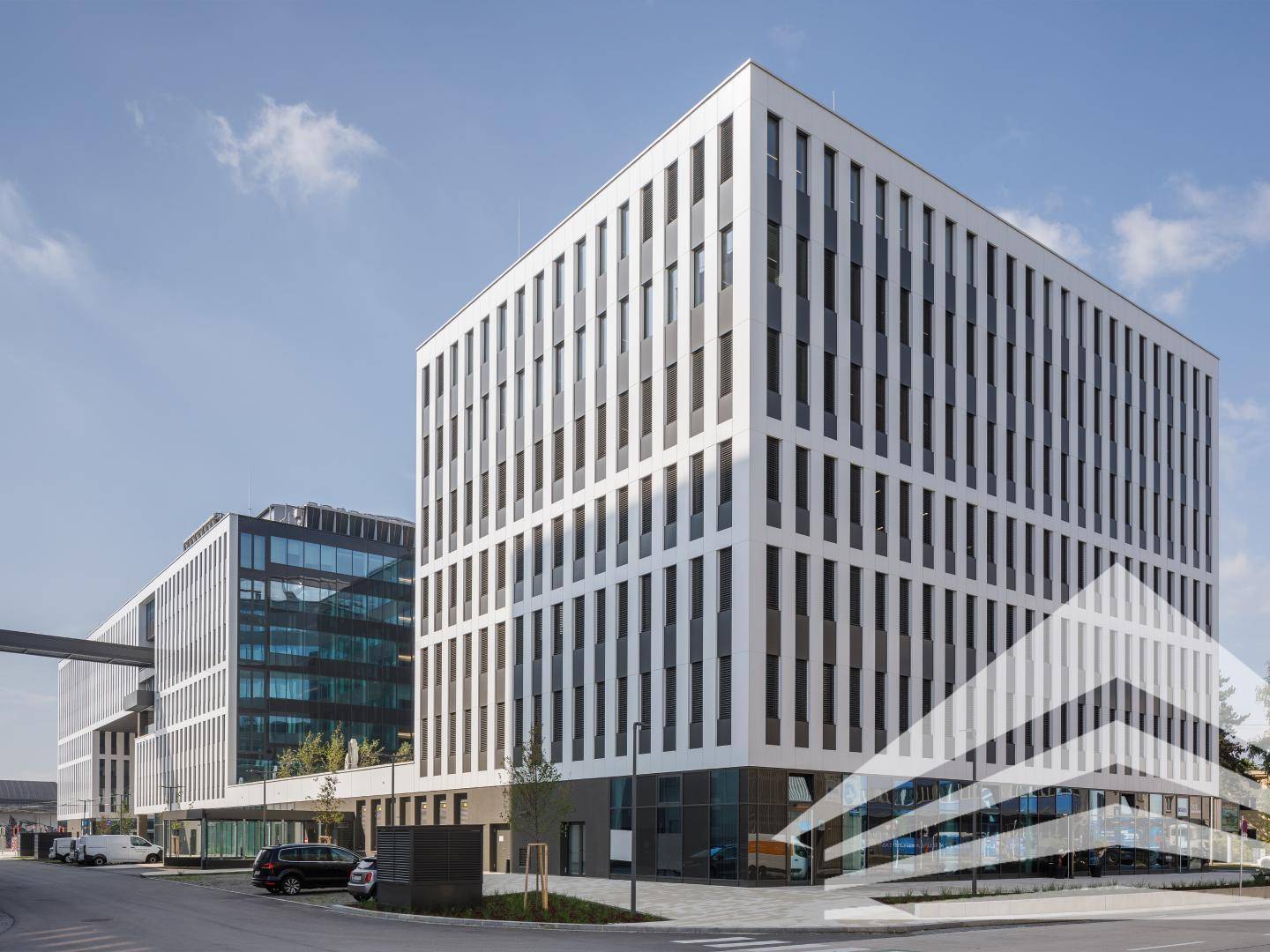 Weitläufiger Blick auf einen modernen Bürokomplex mit mehreren Gebäuden und einer klaren, zeitgenössischen Ästhetik.