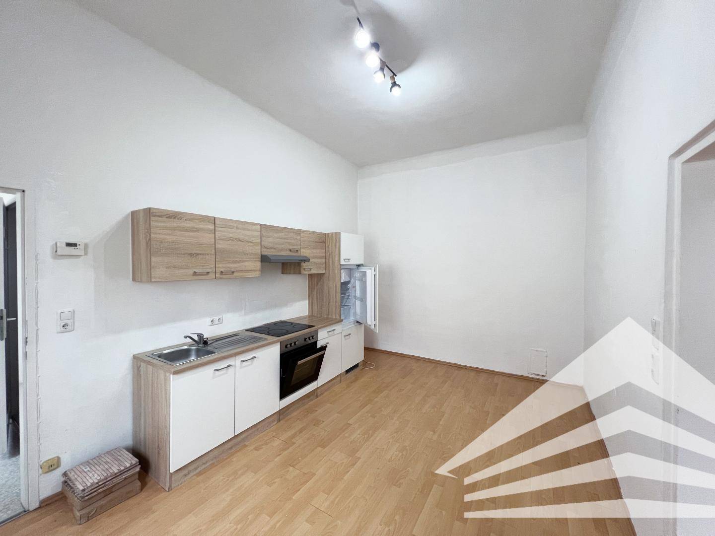 Funktionale Küchenzeile mit Holzfronten und integrierten Geräten in einem hellen Wohnraum.