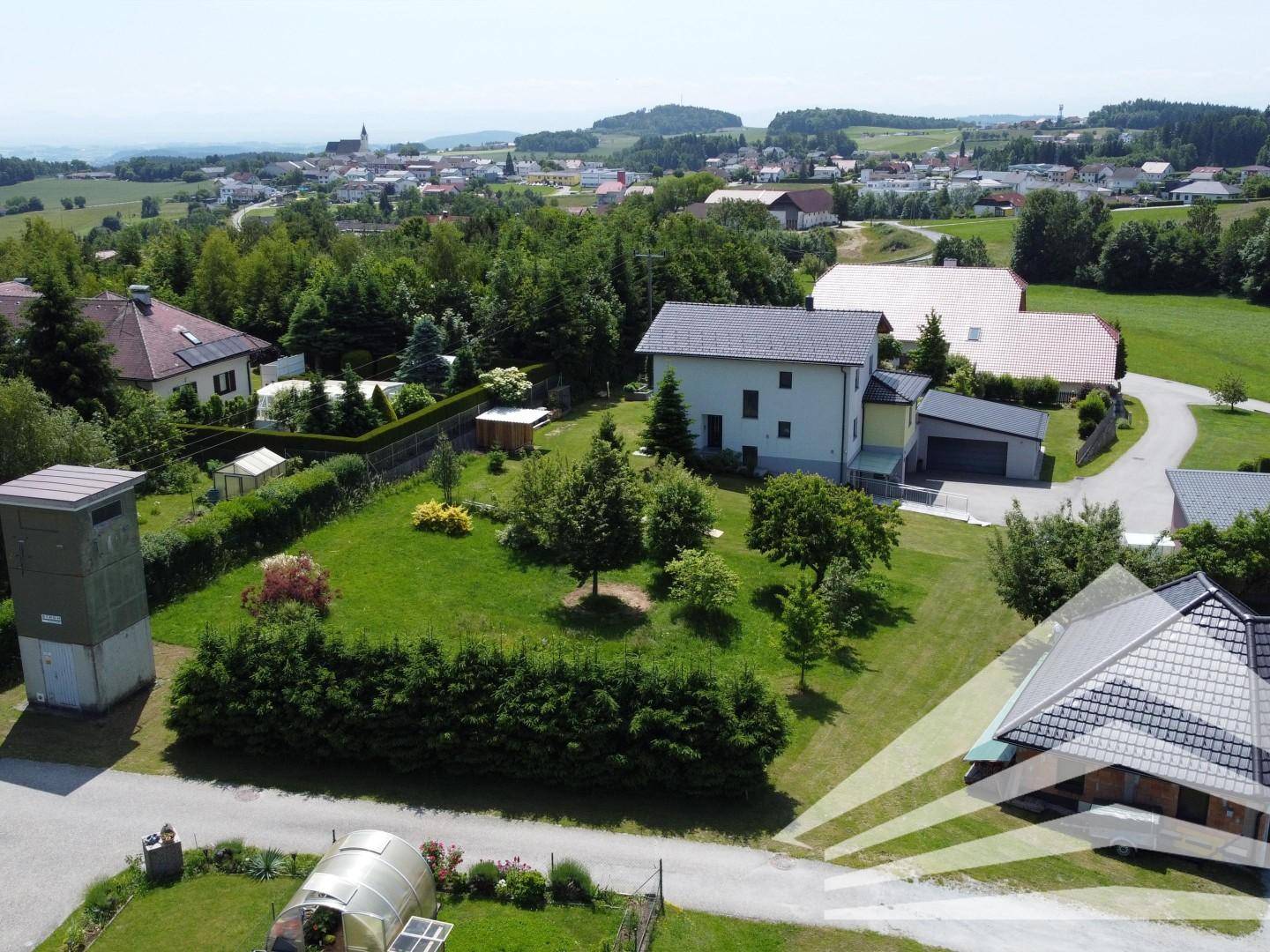 Übersicht des Grundstücks mit umliegender Bebauung und weitem Blick über die grüne Landschaft.
