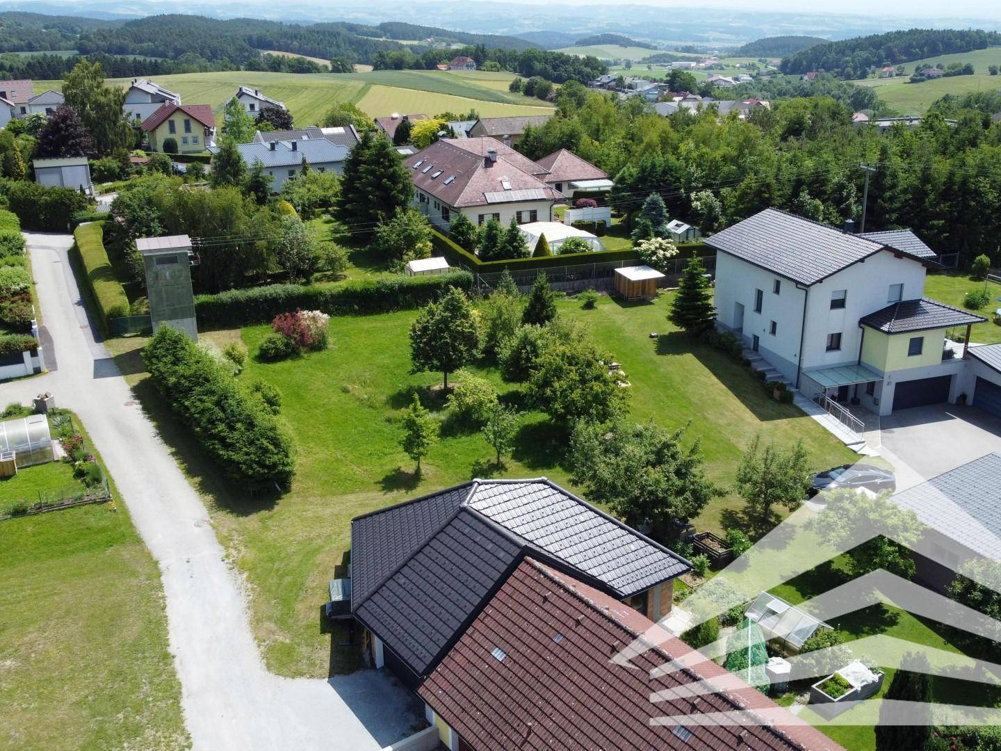 Luftaufnahme des Grundstücks mit angrenzenden Häusern und weitem Blick in die ländliche Umgebung.