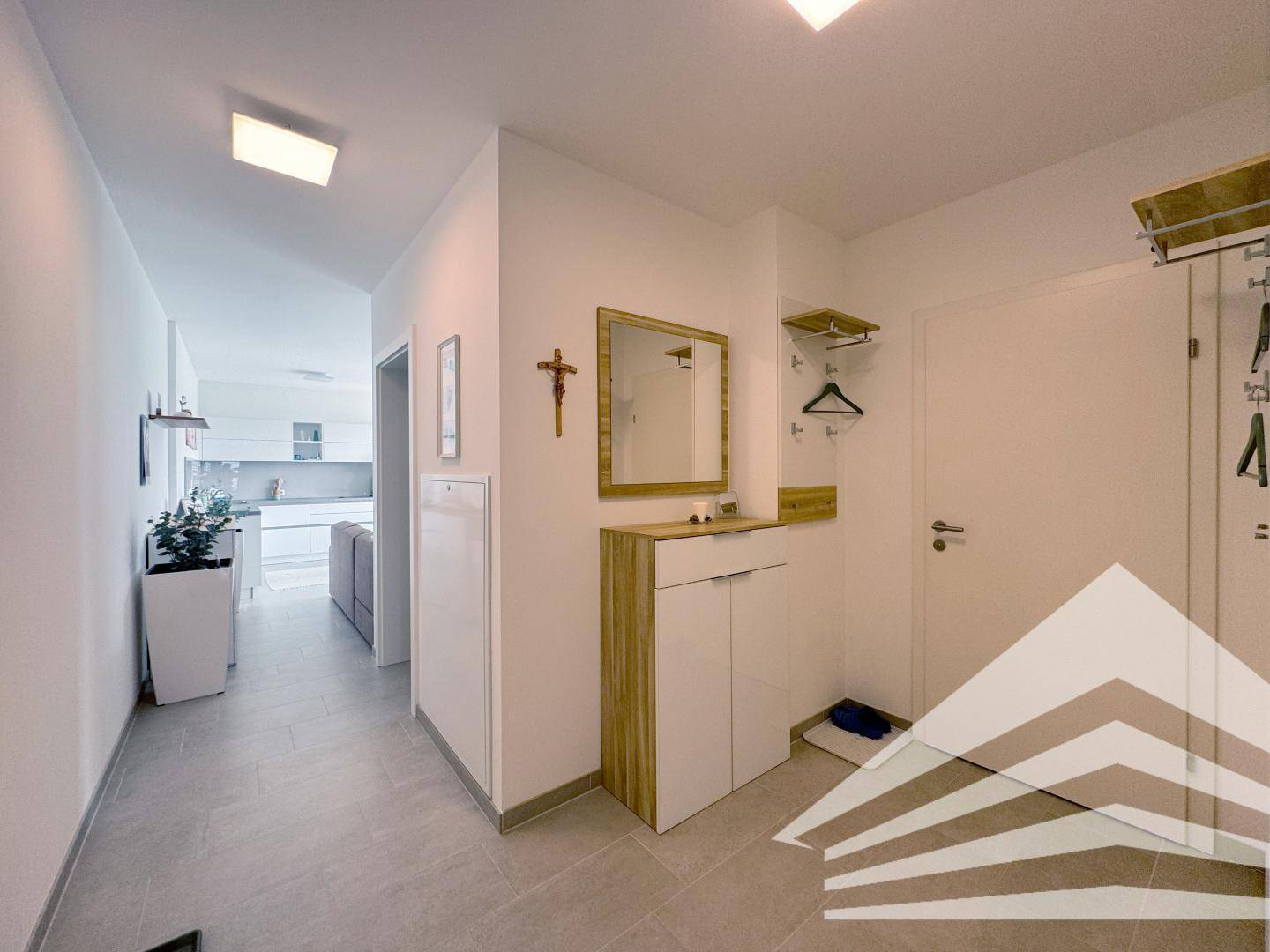 Eingangsbereich mit Garderobe, Spiegel und Kommode, führt in den Wohnbereich.