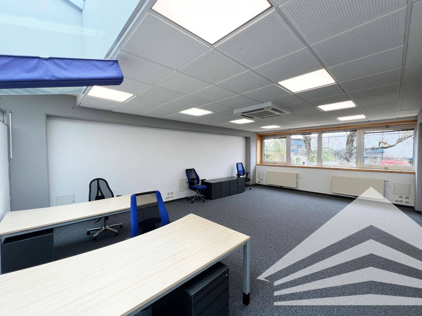 Geräumiges Büro mit Teppichboden, Schreibtischen und Bürostühlen, bereit für neue Mieter.