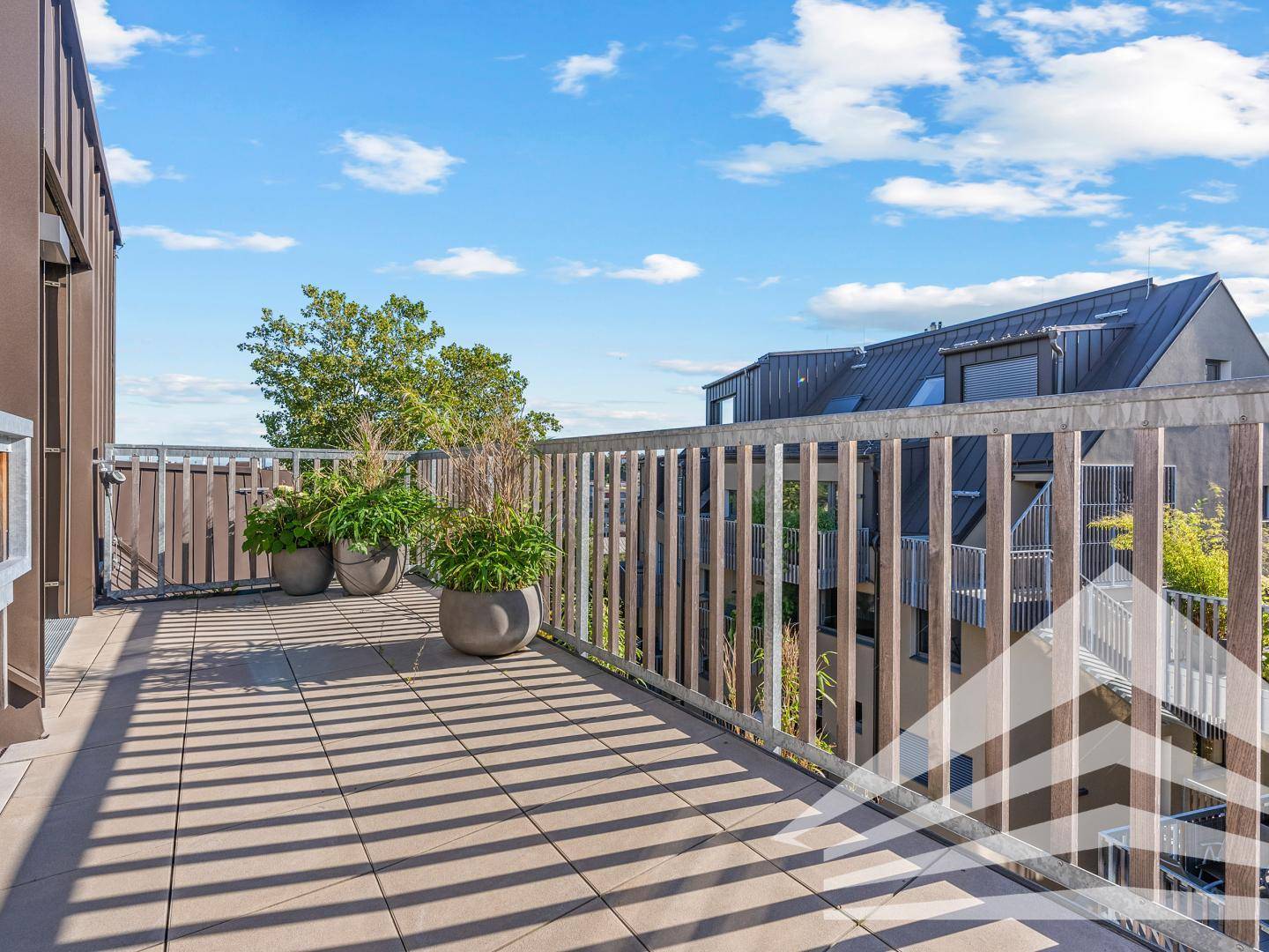Großzügige Dachterrasse mit Fliesenboden und weitem Blick über die Dächer.
