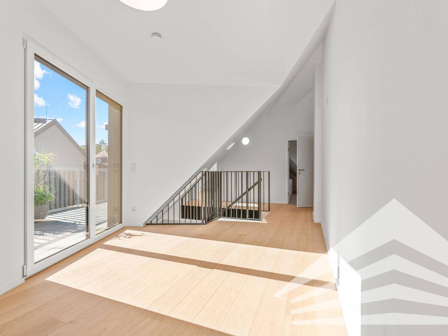 Heller Wohnbereich mit Parkettboden, schräger Decke und großem Fenster mit Terrassenzugang.