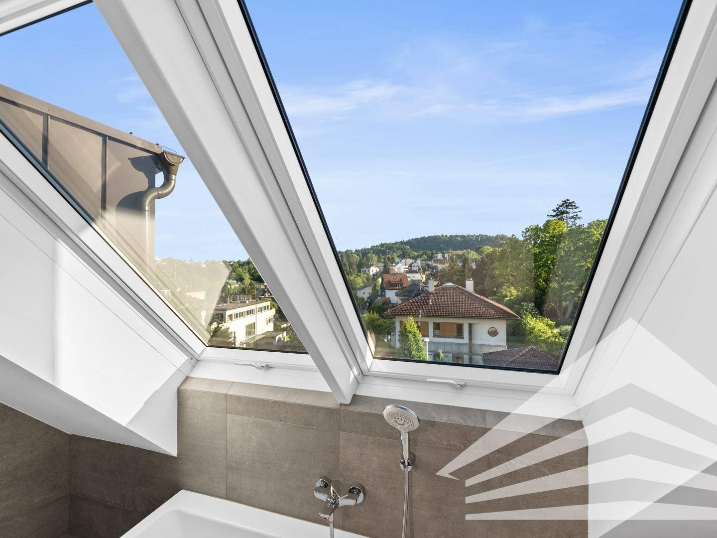 Badezimmer mit Dachfenster und weitem Blick über die Dächer und grüne Umgebung.