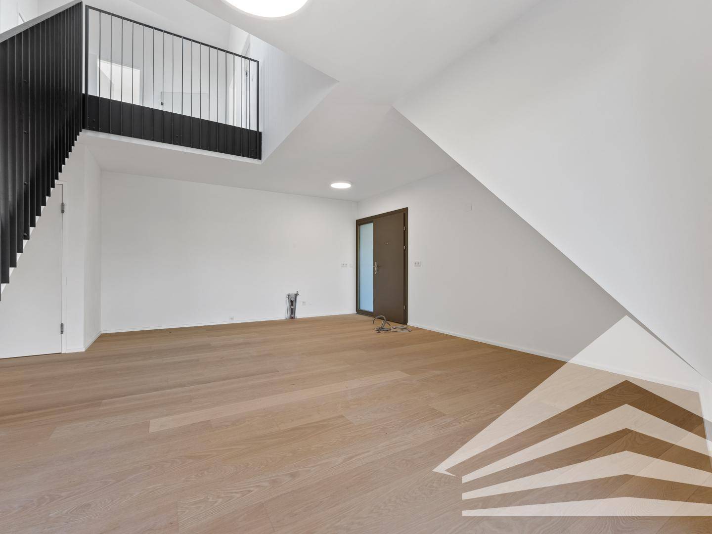 Geräumiger, offener Bereich mit Holzparkettboden und Galerie, ideal für Wohnen und Essen in einem Neubau.
