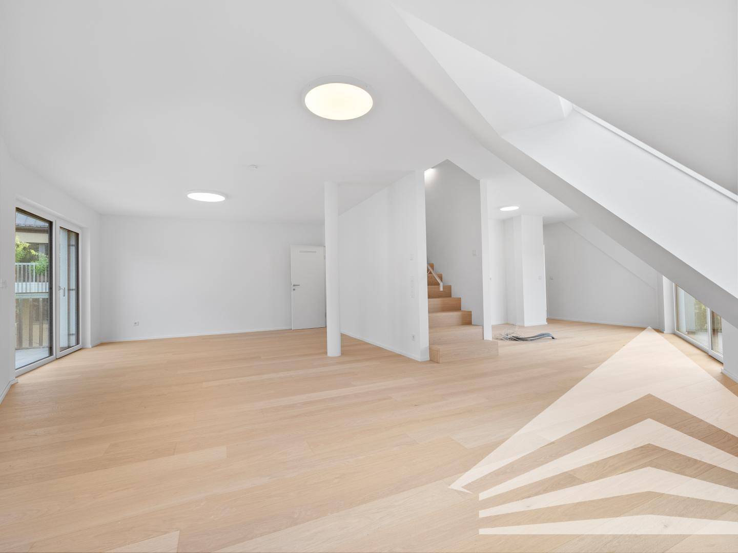Heller, unmöblierter Wohnbereich mit Holzfußboden, Treppenzugang und Balkonzugang, ideal für offenes Wohnen.