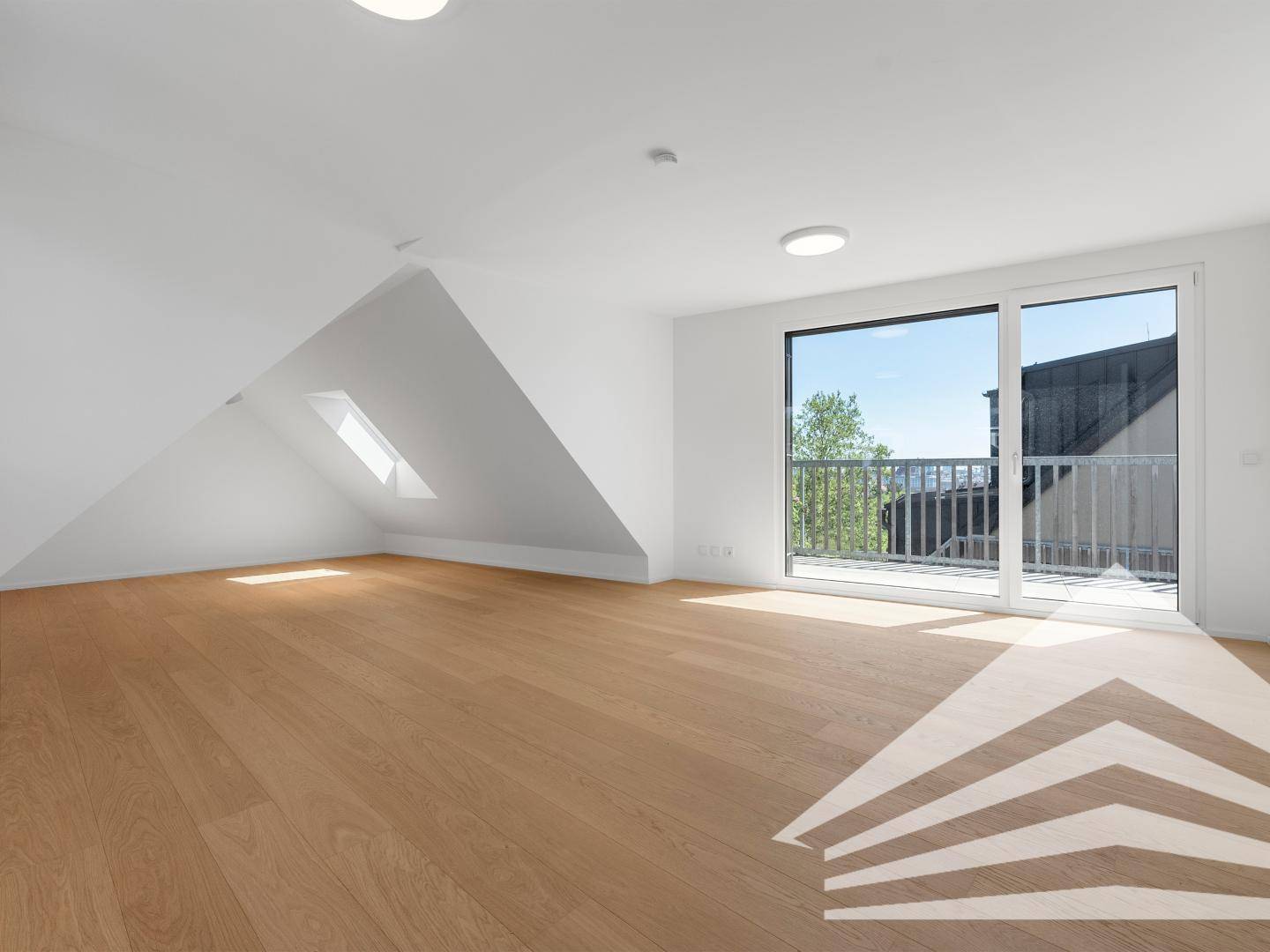 Geräumiger, heller Raum mit Holzboden und Zugang zu einem Balkon.