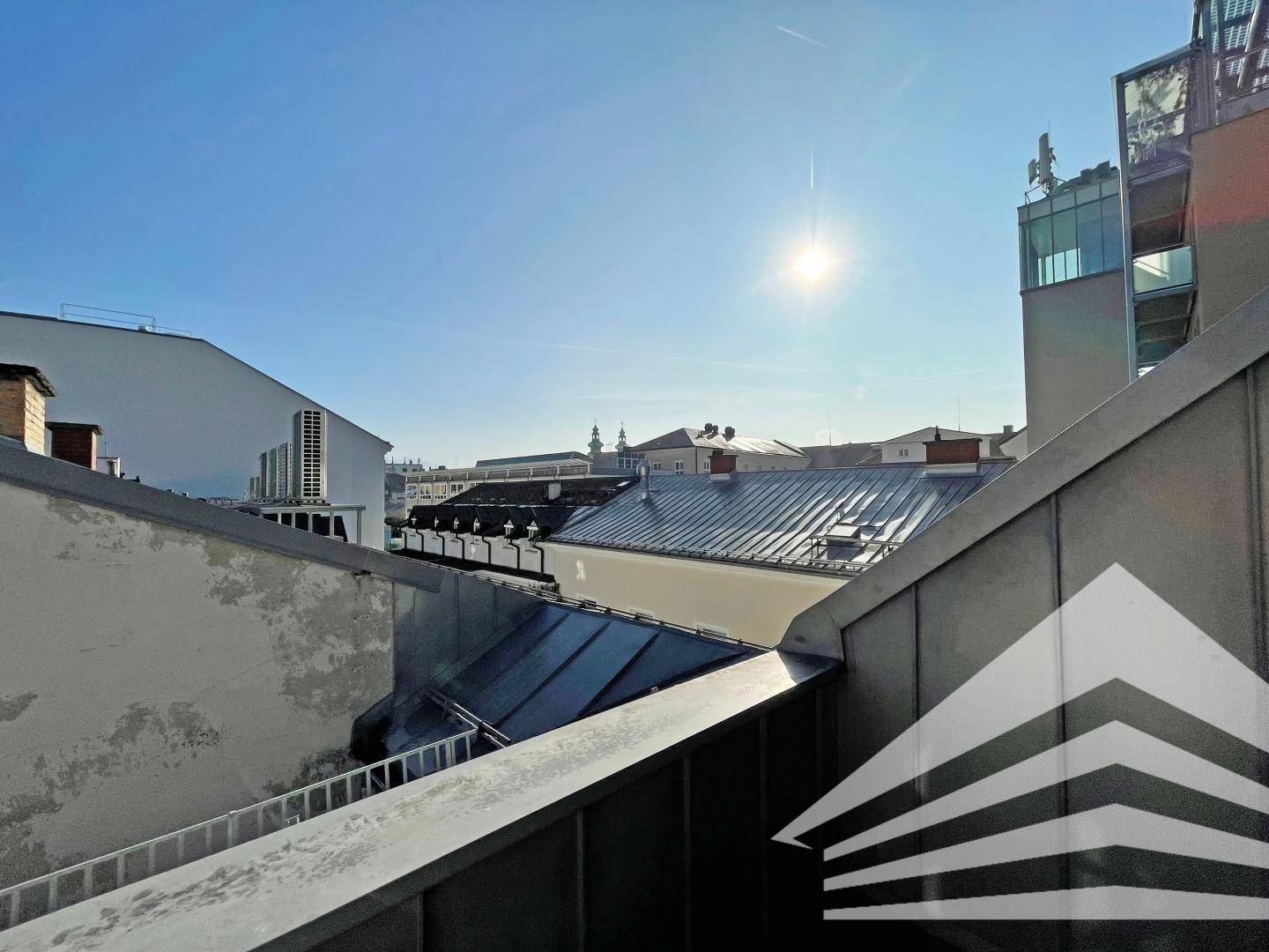 Weitblick über die Dächer der Stadt unter strahlend blauem Himmel mit Sonnenschein.