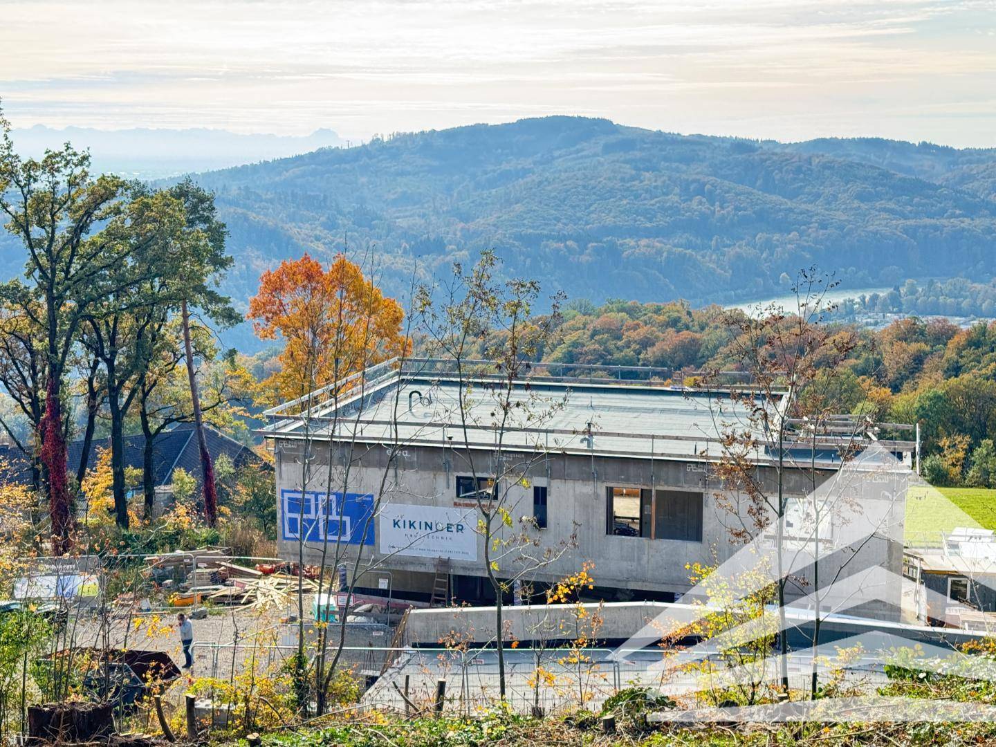 Neubau in Betonbauweise im Rohbauzustand mit weitem Blick auf die hügelige Landschaft.
