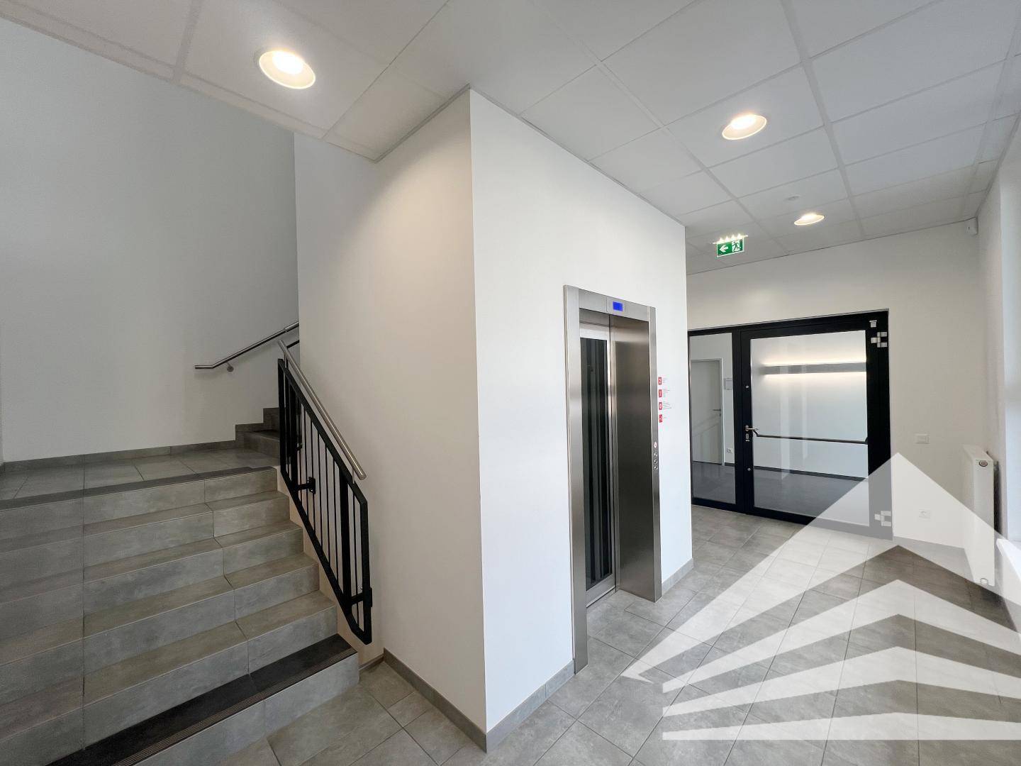 Eingangsbereich mit Treppe, Aufzug und Zugang zu weiteren Büroräumen.