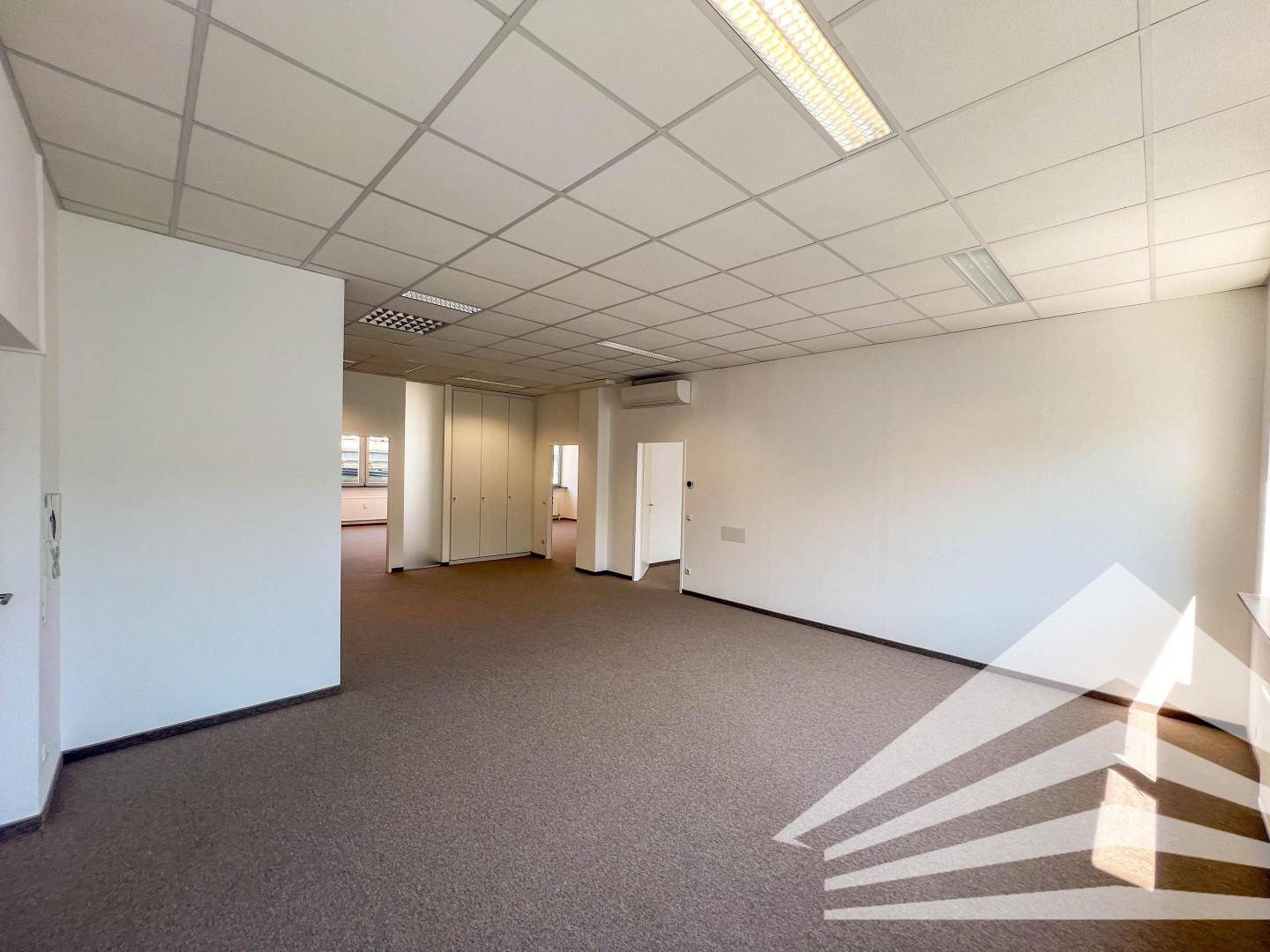 Helles Büro mit Teppichboden, abgehängter Decke und integrierter Beleuchtung, bereit zur Nutzung.