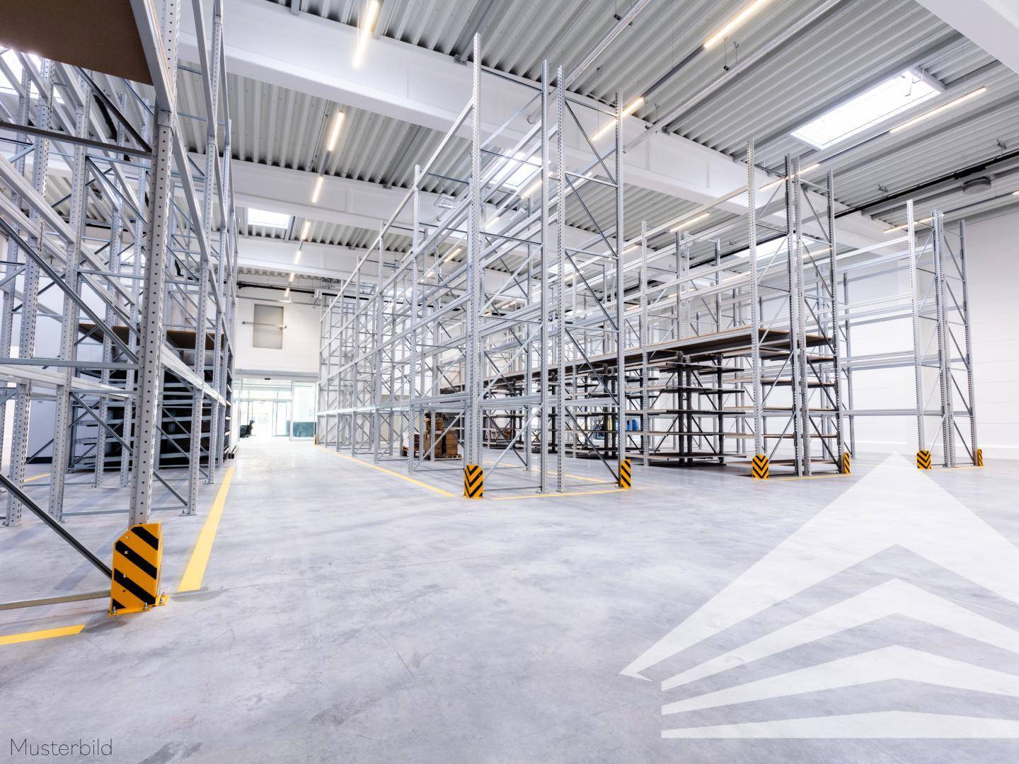 Innenansicht einer Lagerhalle mit hohen Regalsystemen, Betonboden und Oberlichtern für Tageslicht.