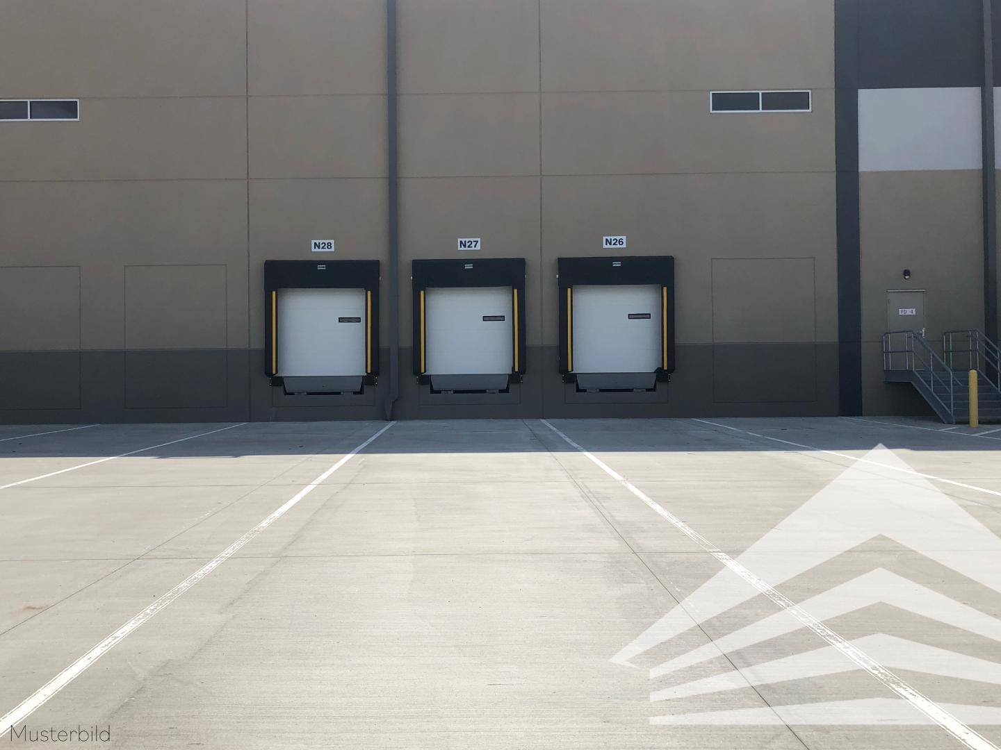 Außenansicht eines Industriegebäudes mit drei Laderampen und großem Vorplatz.