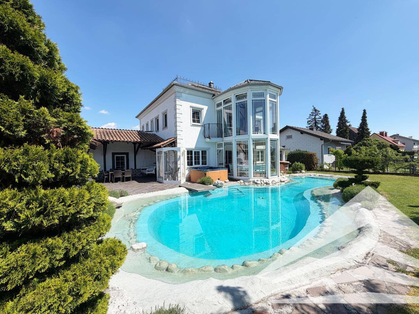 Ansicht des Hauses mit großem Pool, integriertem Whirlpool und weitläufigem, sonnigem Gartenbereich.