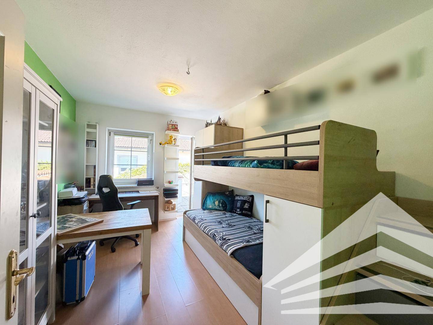 Kinderzimmer mit Etagenbett, Schreibtisch und grünen Wänden, ideal zum Schlafen und Lernen.
