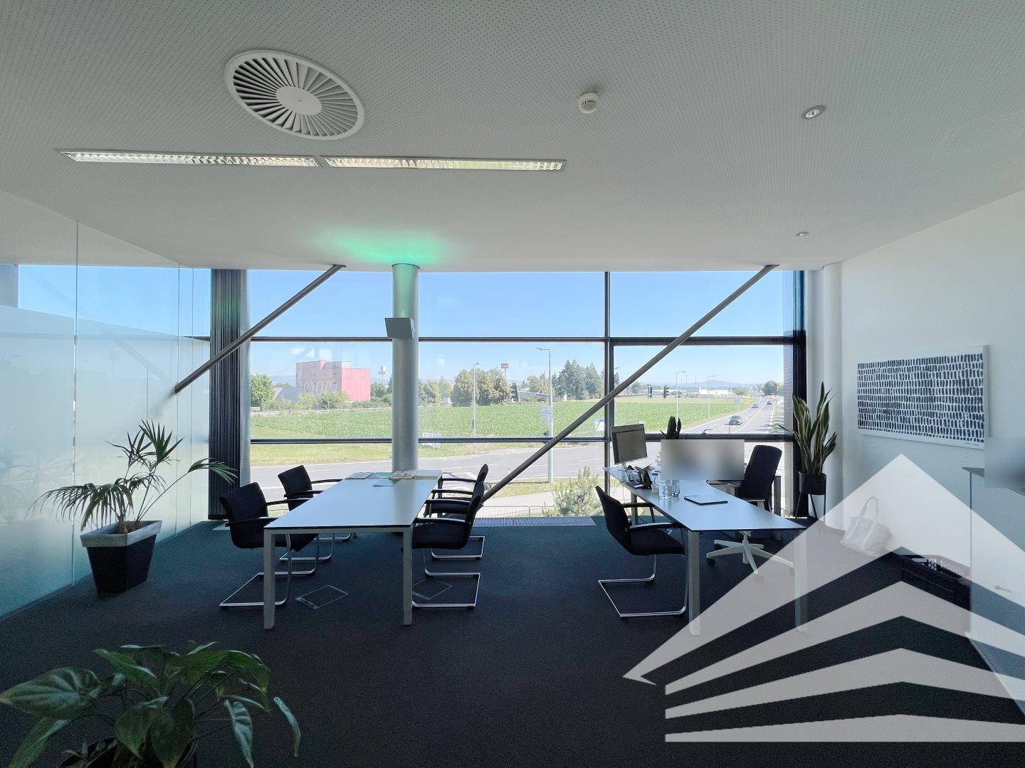 Moderner Besprechungsraum mit großen Fenstern, die viel natürliches Licht hereinlassen und eine weite Aussicht bieten.