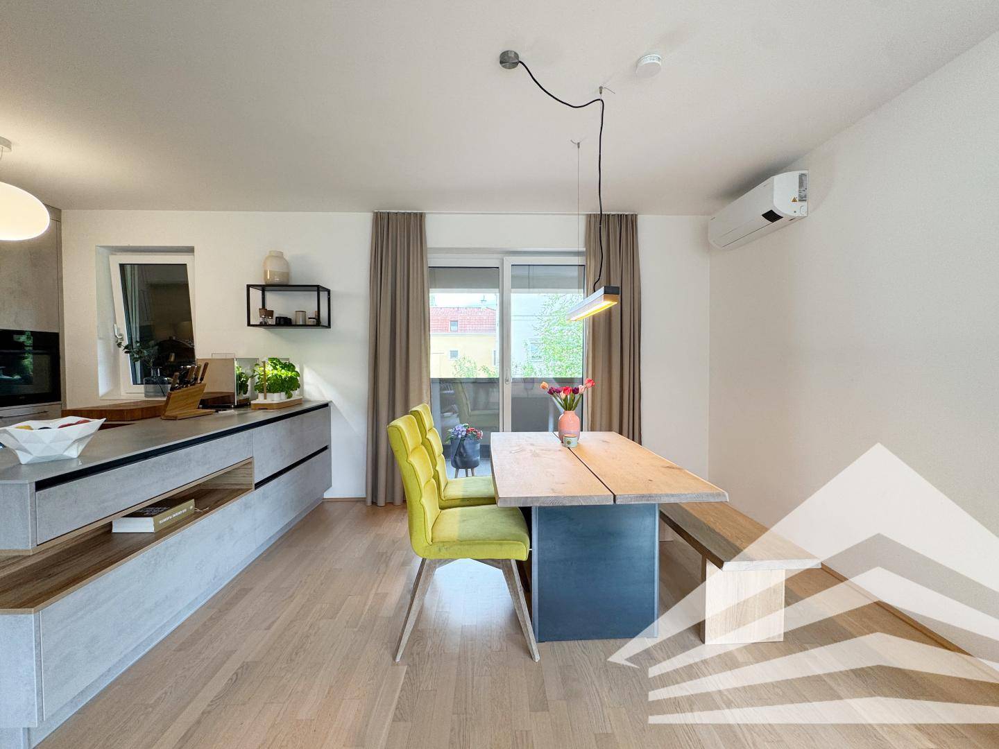 Moderne Küche mit Kücheninsel, Holzelementen und Essbereich mit Zugang zum Balkon.