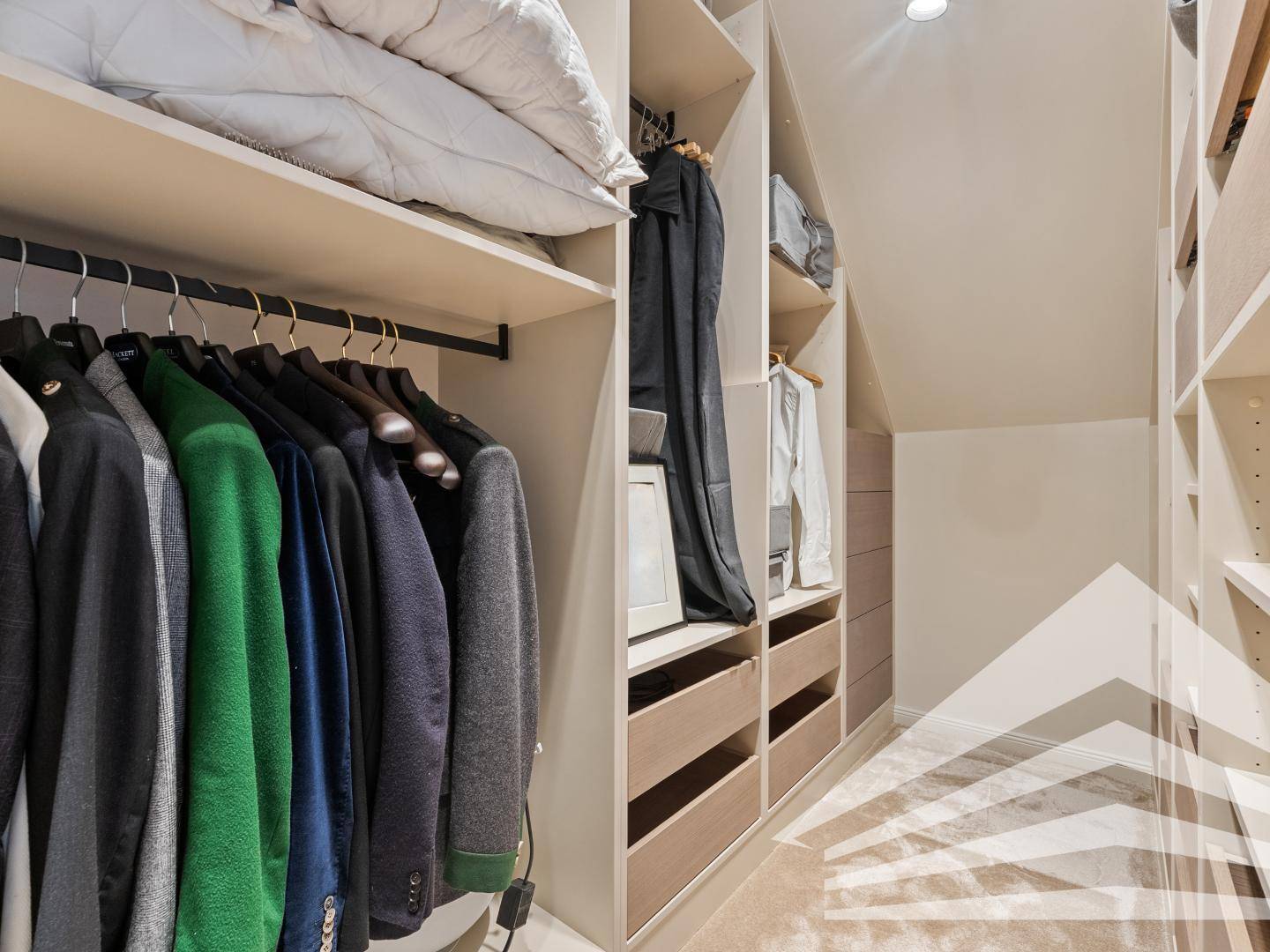 Geräumiger begehbarer Kleiderschrank mit maßgefertigten Regalen und viel Stauraum.