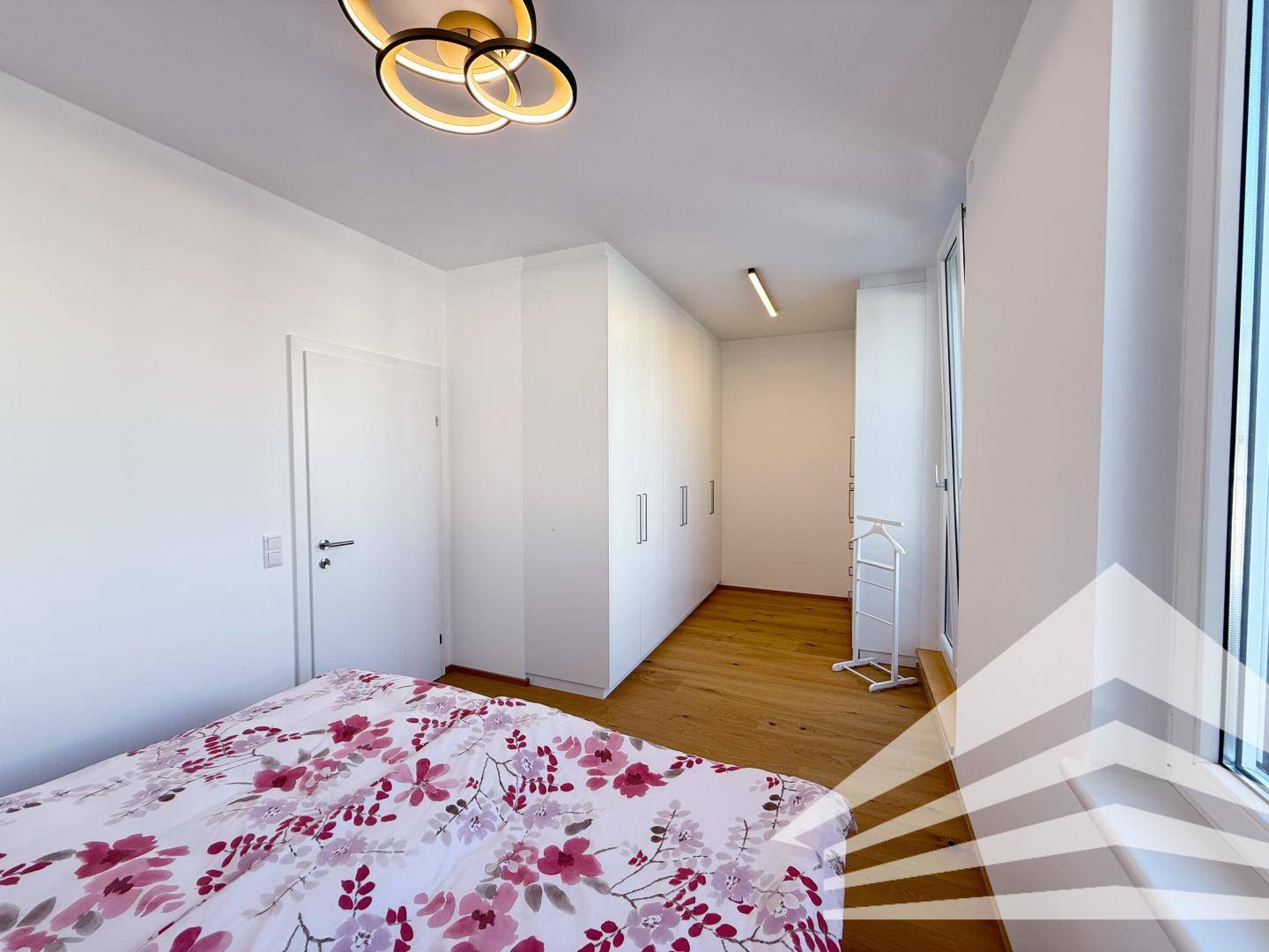 Helles Schlafzimmer mit Holzboden und Einbauschränken, bietet viel Stauraum.