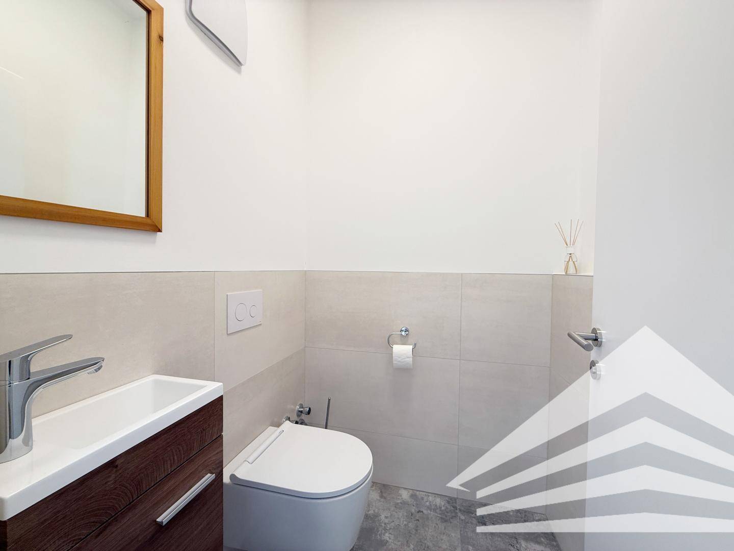 Modernes Gäste-WC mit Wand-WC und kleinem Waschbecken, in schlichtem Design.
